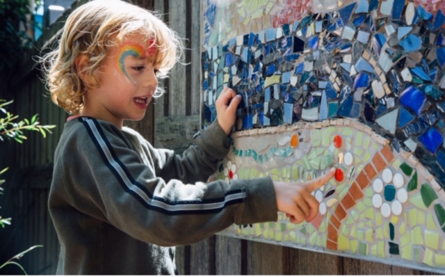 Child looking at mosaic animal mural